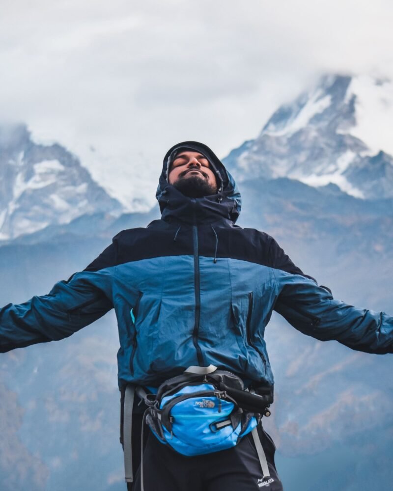 Man with arms open breathing in fresh mountain air